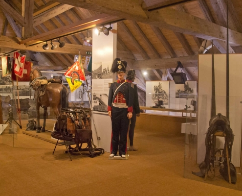 Salle "Le cheval dans l'armée" au Musée Suisse du Cheval, La Sarraz. Immersion dans l'histoire équestre et les métiers traditionnels. Exposition interactive sur le patrimoine artisanal lié au cheval. Ateliers ludiques au Château.