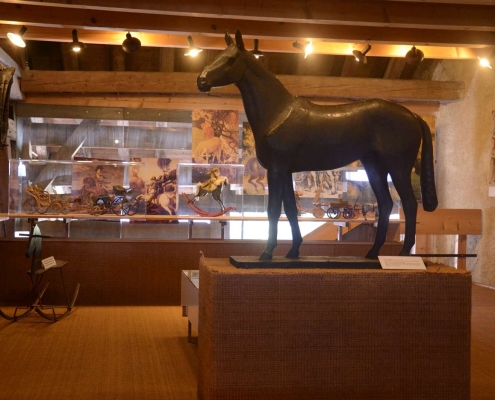 Salle "La vie du cheval" au Musée Suisse du Cheval, La Sarraz. Immersion dans l'histoire équestre et les métiers traditionnels. Exposition interactive sur le patrimoine artisanal lié au cheval. Ateliers ludiques au Château.